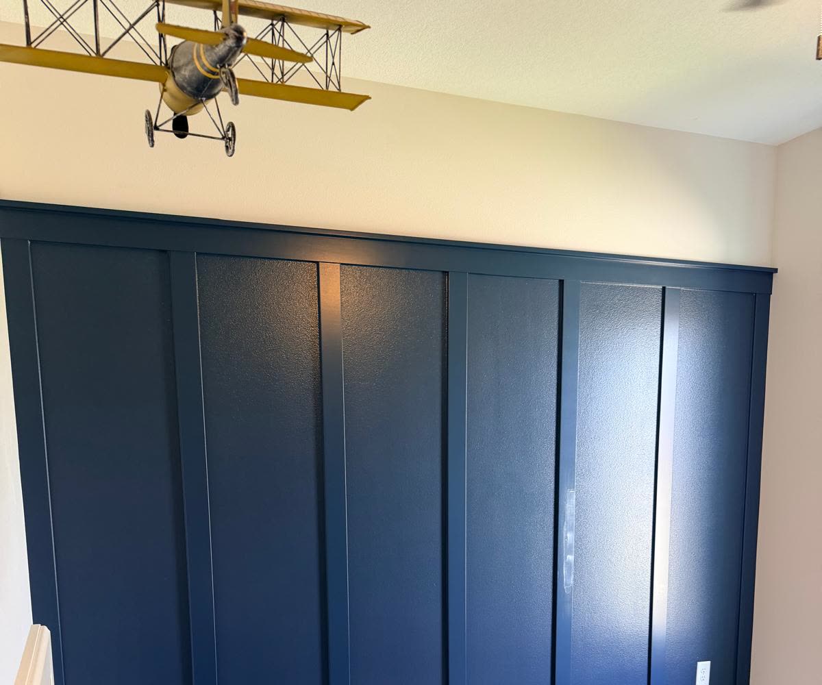 Navy blue board and batten accent wall in a bedroom