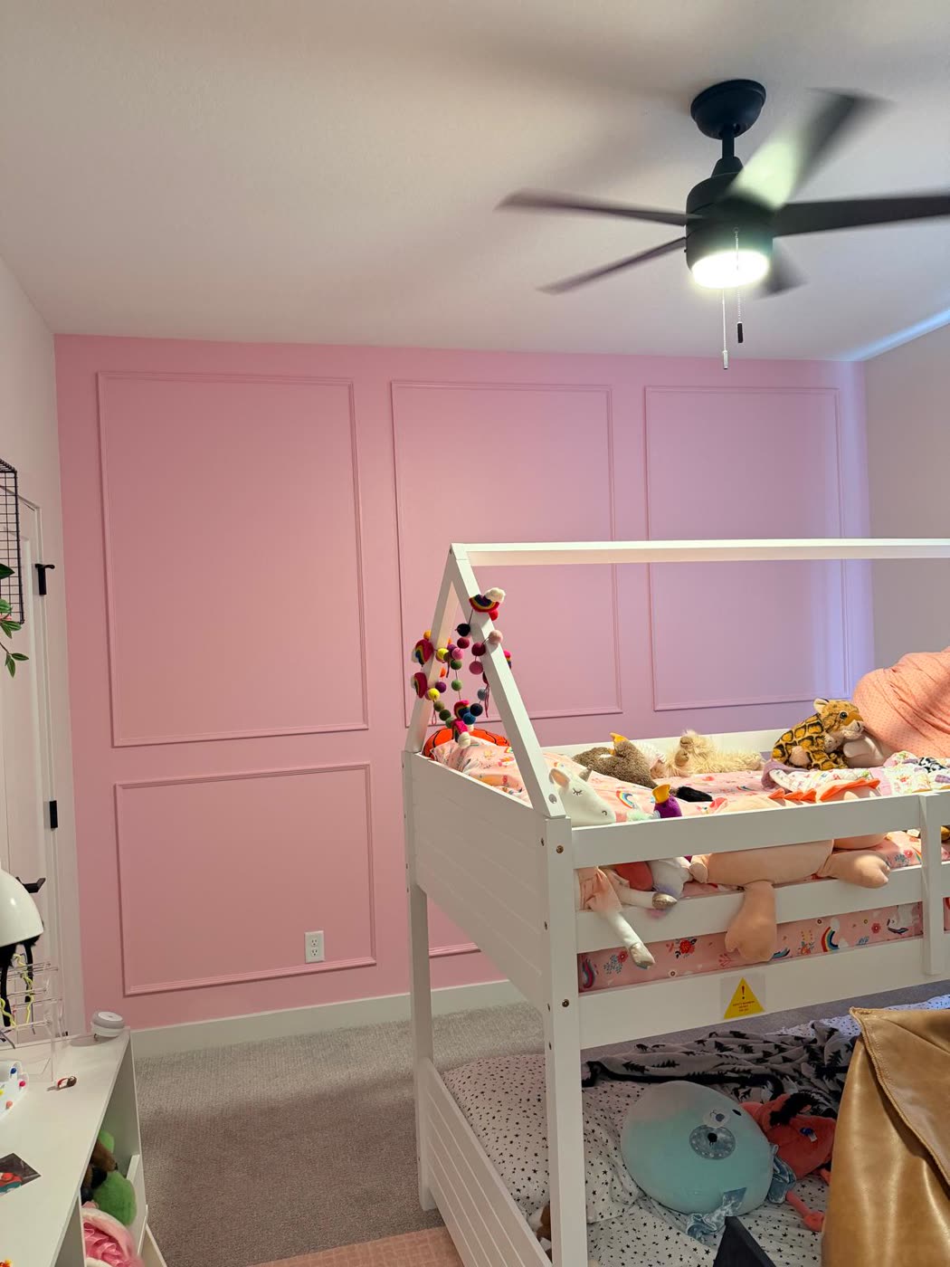 Pink accent wall with painted picture-frame molding in a child's bedroom